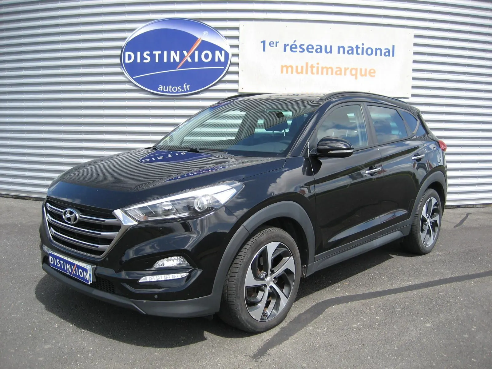 Hyundai Tucson noir fantom metal en 3/4 avant droit, avec jantes alliage et calandre chromée visible.