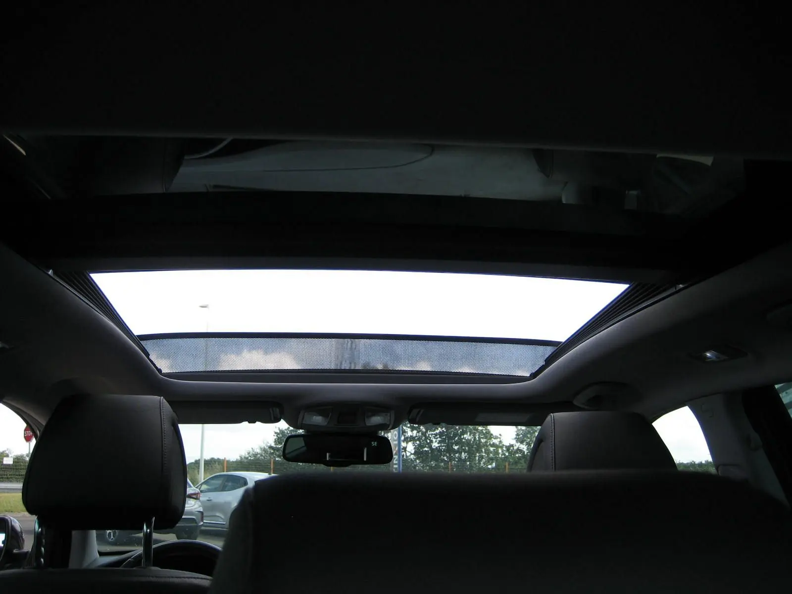 Vue intérieure arrière montrant le toit ouvrant panoramique du Hyundai Tucson noir fantom metal de 2016.