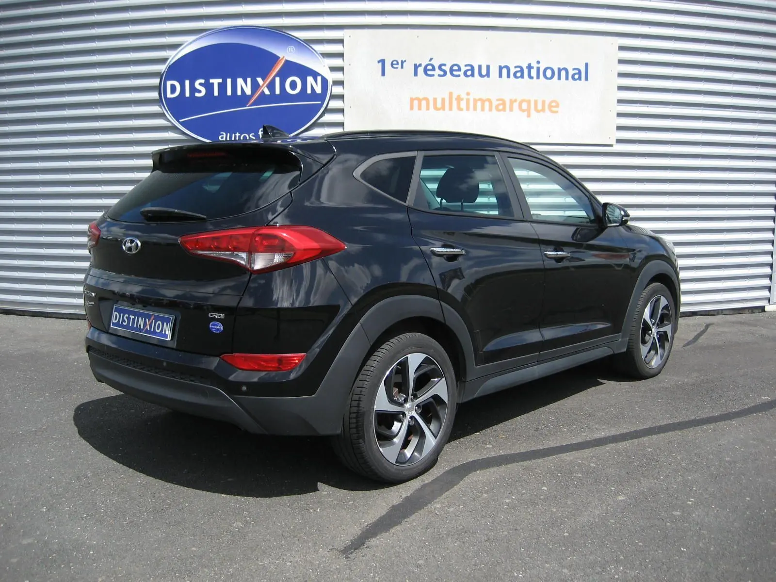 Hyundai Tucson noir fantom metal vu en 3/4 arrière droit, avec jantes alliage et feux arrière distinctifs.