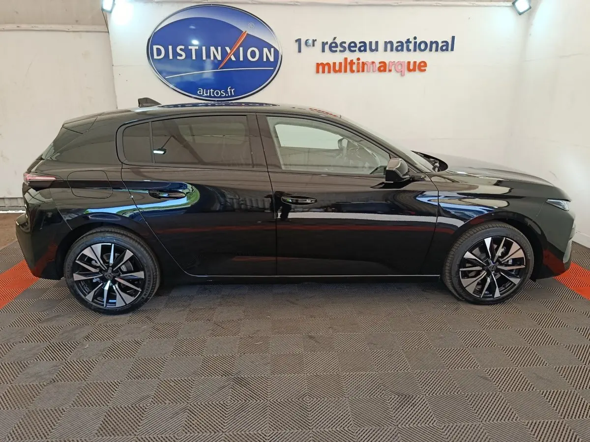 Profil droit d'une Peugeot 308 noire 2026, avec jantes alliage et vitres teintées, en intérieur showroom.