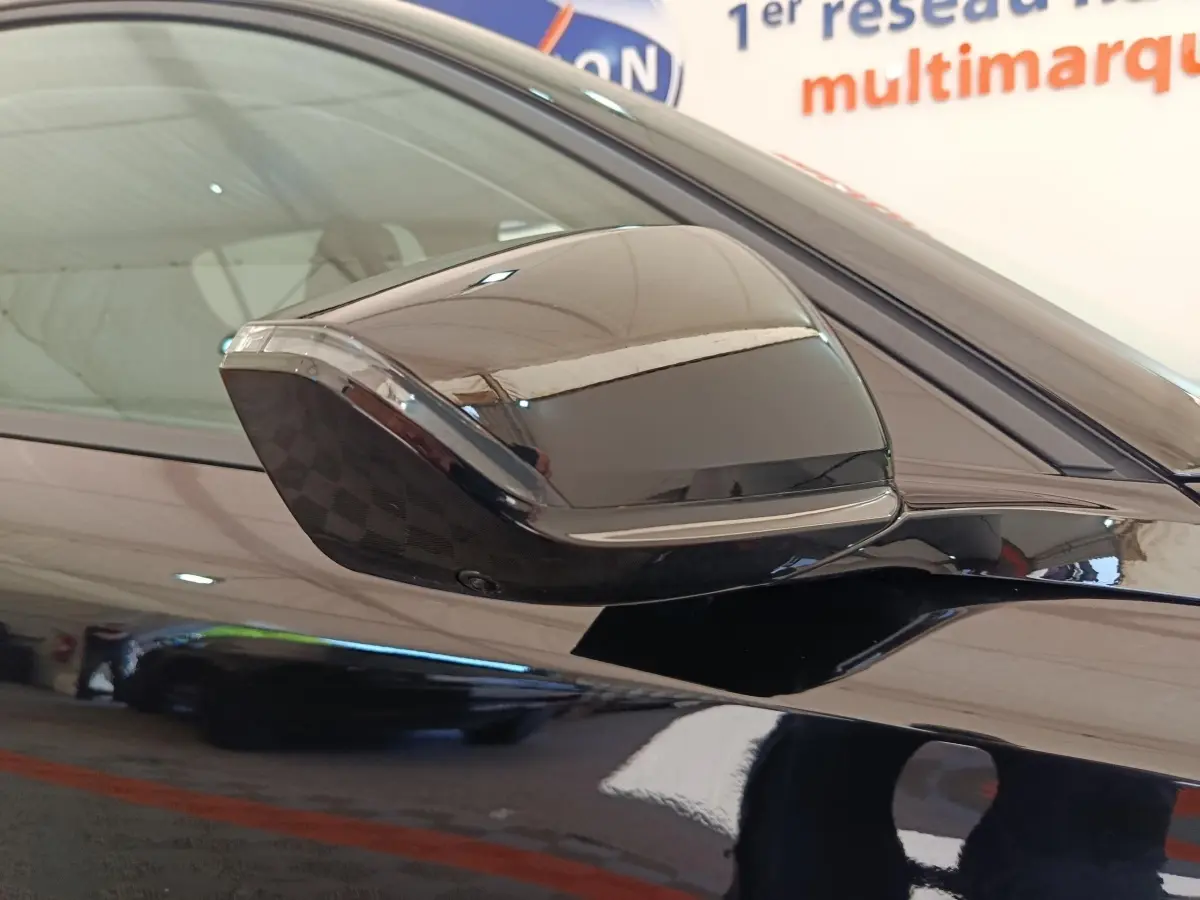 Rétroviseur côté gauche noir brillant de la Peugeot 308 2026, avec surface lisse et reflet net.
