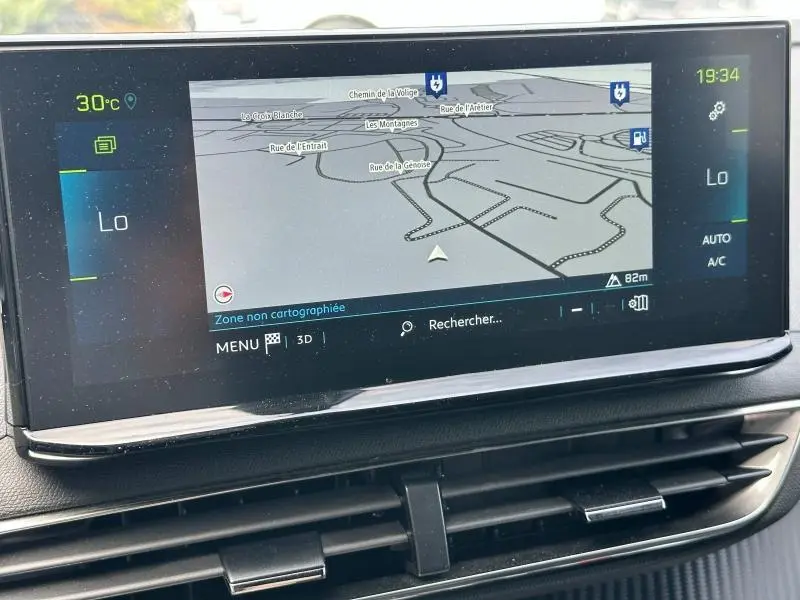 Écran tactile central du Peugeot 3008 Hybride Rechargeable 2024 affichant la navigation et la climatisation en mode automatique.