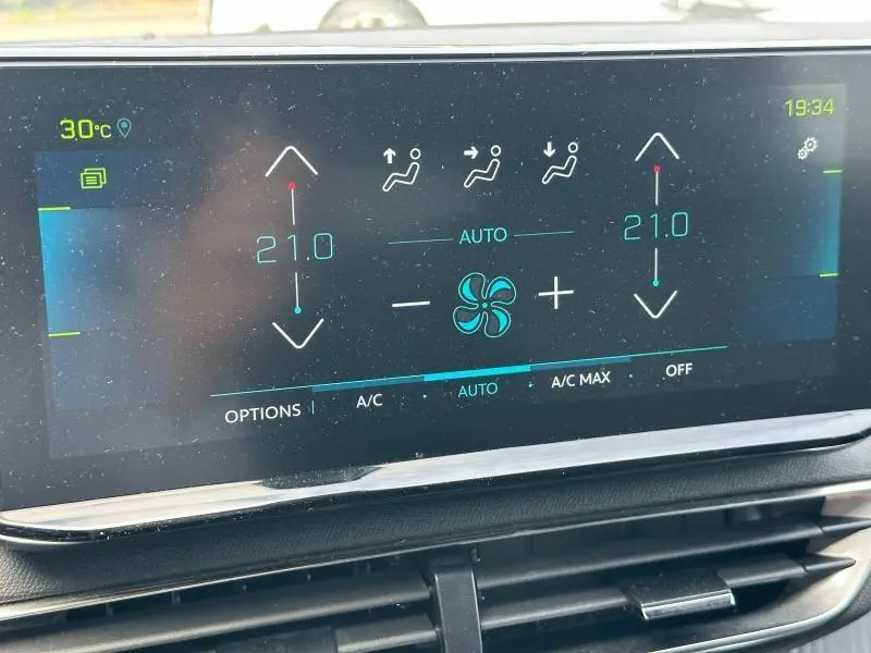 Écran tactile du système de climatisation bi-zone du Peugeot 3008 noir, affichant 21°C et réglages de ventilation.