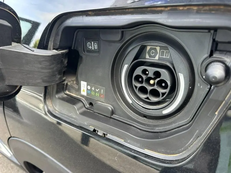 Gros plan sur la trappe de recharge hybride noire Perla Nera du Peugeot 3008 Hybride Rechargeable 2024.