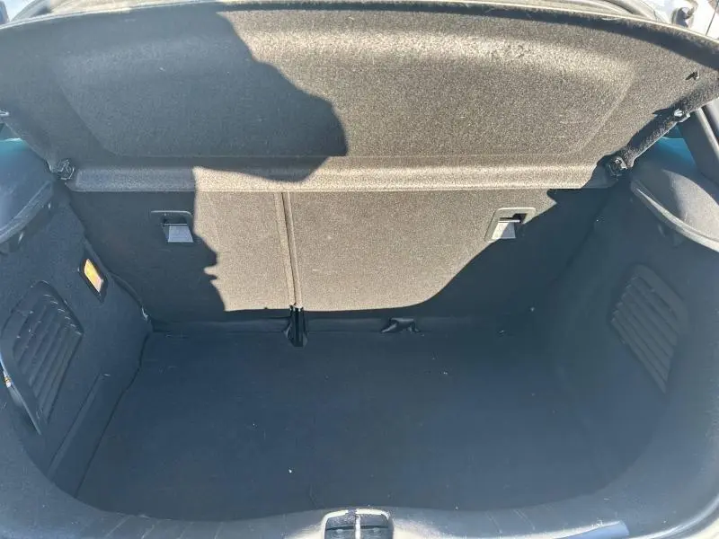 Coffre ouvert vu de dessus d'une DS3 noire de 2016, montrant un espace de rangement propre et bien fini.