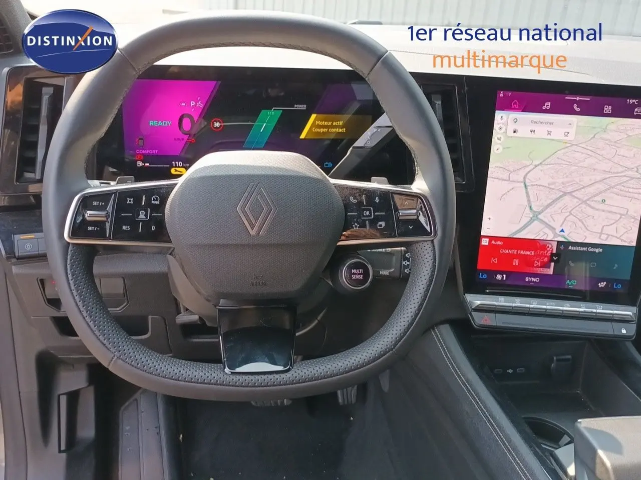 Vue frontale du volant Renault sur tableau de bord numérique avec écran tactile vertical et finition noire intérieure.