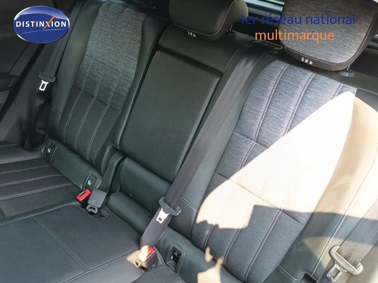Vue rapprochée des sièges arrière en tissu gris et cuir noir du Renault Austral E-Tech 2025, avec ceinture de sécurité visible.