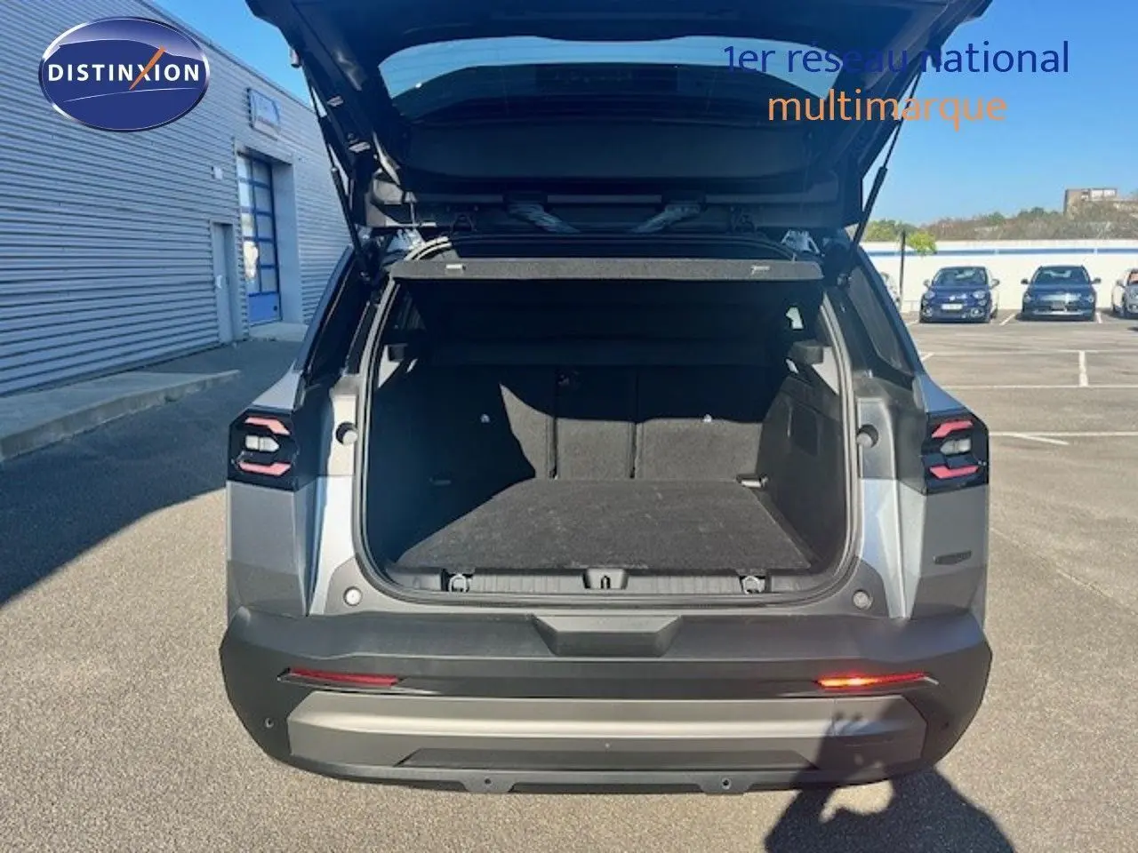 Vue arrière d'un Jeep Compass 2026 gris Yosemite métal avec coffre ouvert et toit noir visible en extérieur.