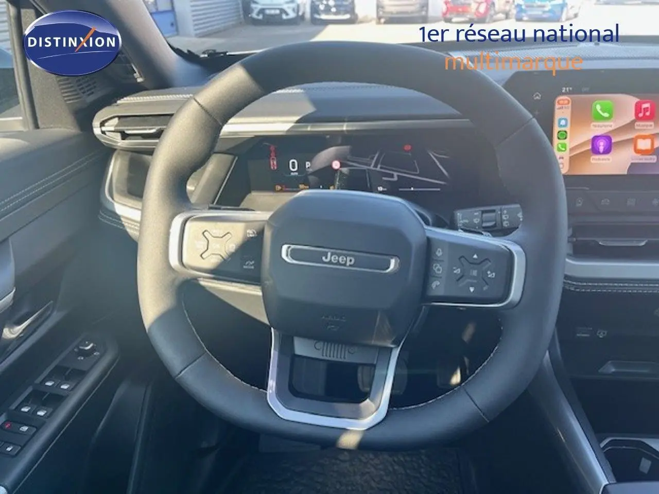 Vue intérieure centrée sur le volant Jeep du Compass 2026, avec tableau de bord numérique et écran tactile couleur.