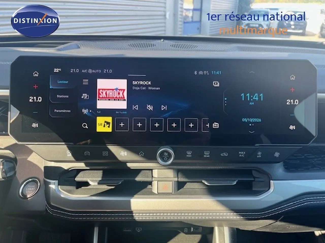 Vue du tableau de bord du Jeep Compass 2026, écran tactile large affichant radio et climatisation, ambiance intérieure noire moderne.