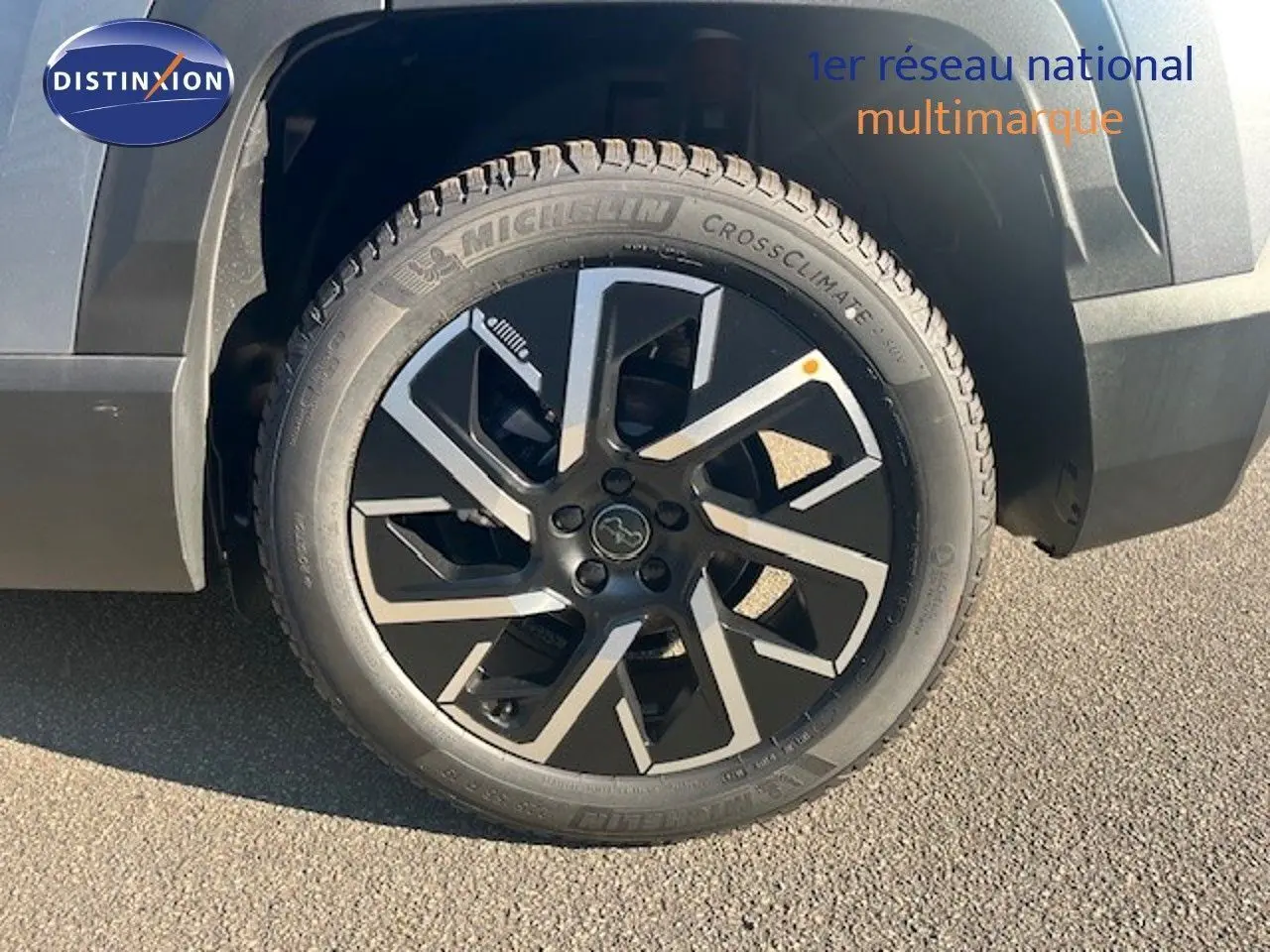 Gros plan sur la roue avant droite du Jeep Compass gris Yosemite métal avec jante noire et argentée au design moderne.