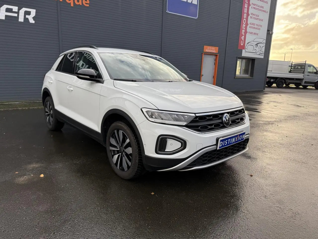 Volkswagen T-Roc blanc pur en 3/4 avant droit, avec jantes alliage Zürich et calandre noire distinctive.