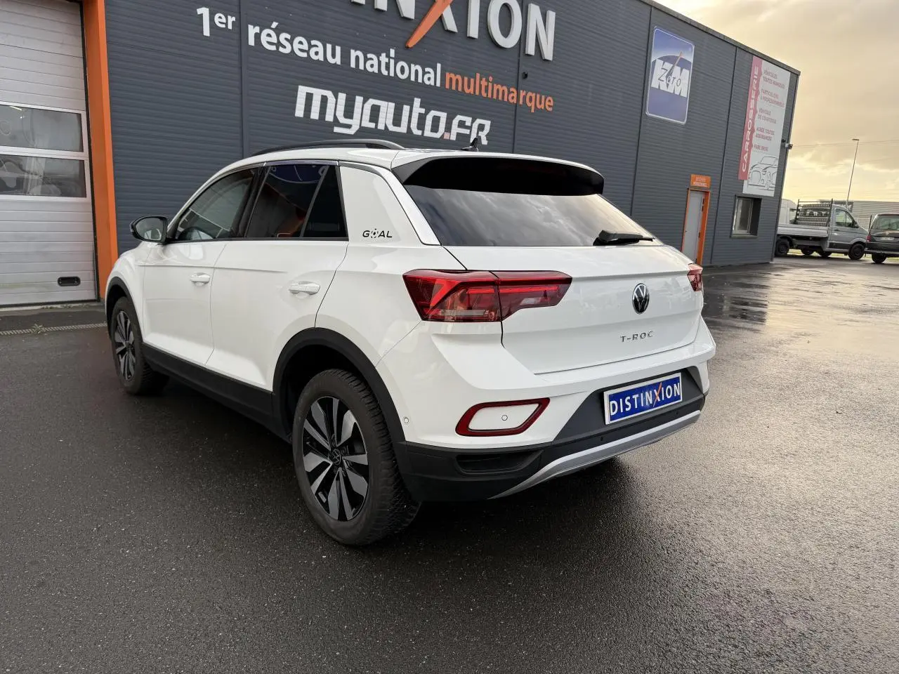 Vue 3/4 arrière droite du Volkswagen T-Roc blanc pur avec jantes alliage Zürich et logo Goal sur le montant C.