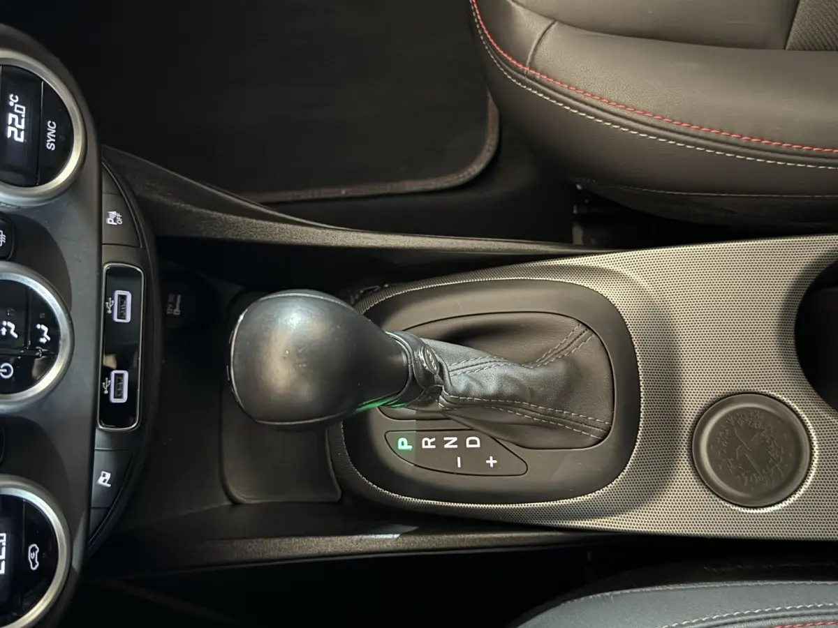 Vue rapprochée de la console centrale noire du Fiat 500X 2021, mettant en valeur le levier de vitesse automatique et les commandes climatisation.