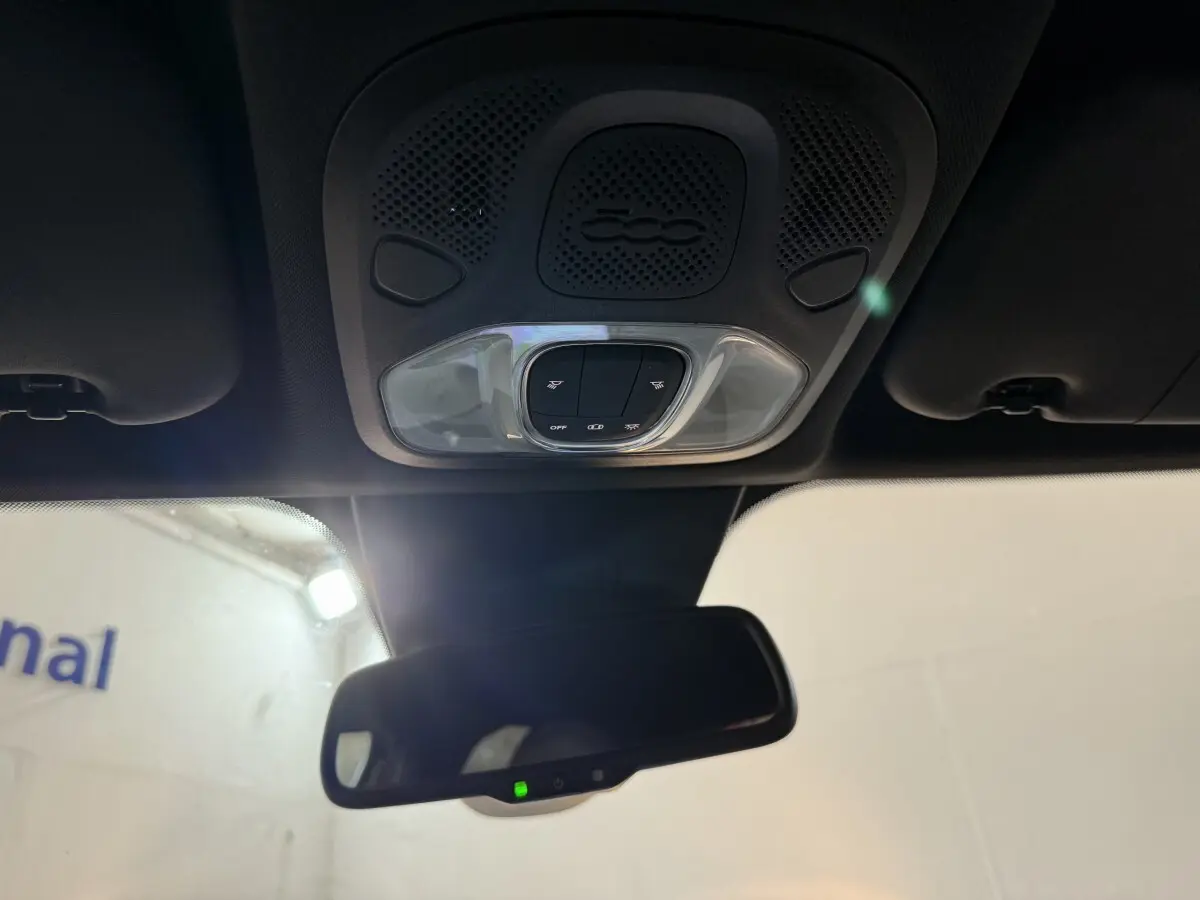 Plafonnier avec commandes d’éclairage et logo 500 au-dessus du rétroviseur intérieur d’une Fiat 500X noire.