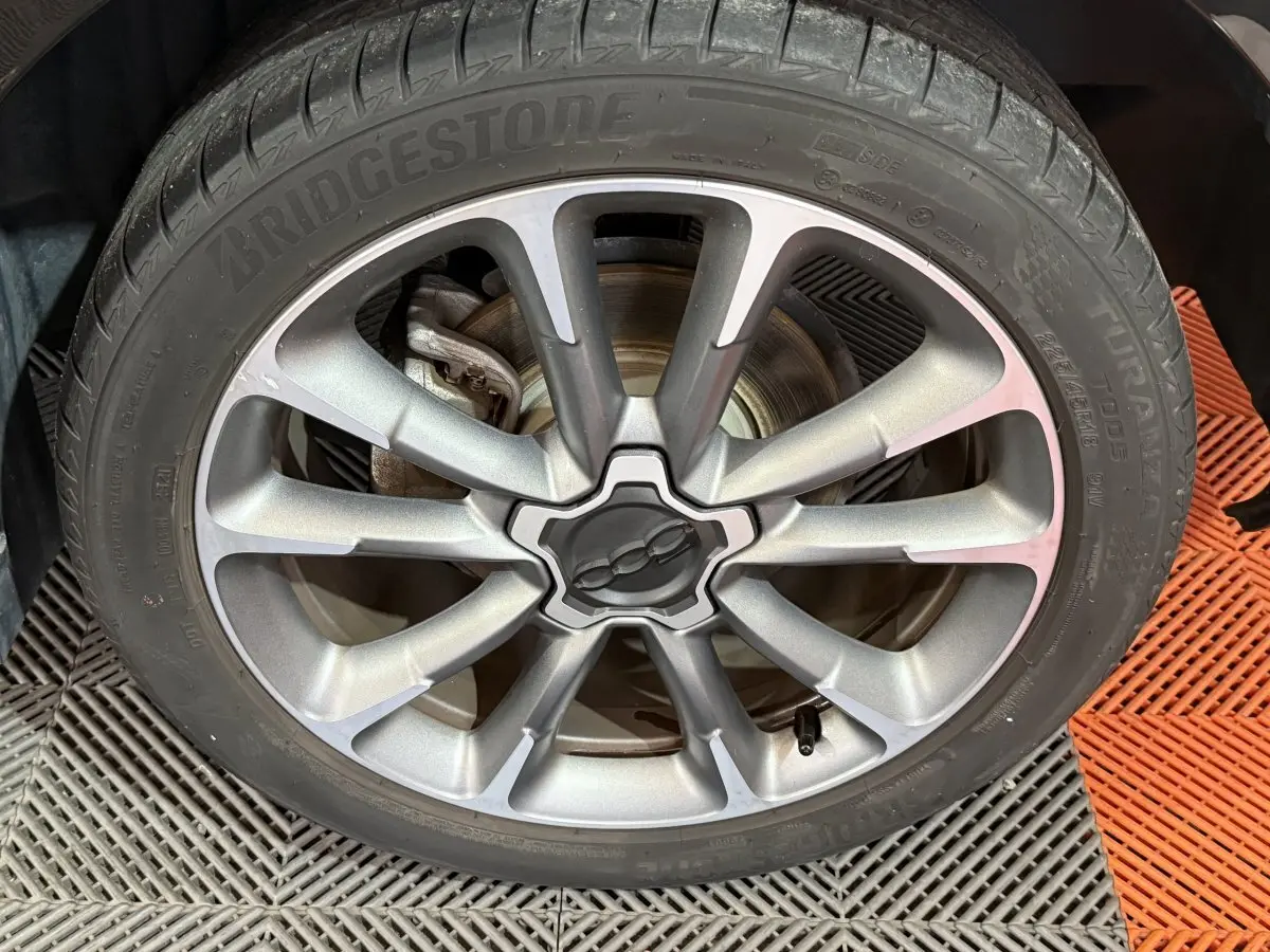 Gros plan sur la jante argentée du FIAT 500X 2021 avec logo central et pneu Bridgestone Turanza.