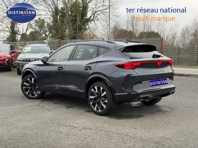 Vue 3/4 arrière droite d'une CUPRA Formentor 1.5 eTSI Hybrid 2025 en gris Graphène avec jantes noires distinctives.