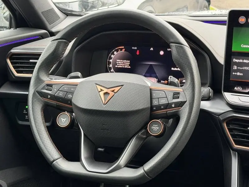 Vue rapprochée du volant multifonction de la CUPRA Formentor 1.5 eTSI Hybrid 2025 avec logo cuivre et tableau de bord numérique.