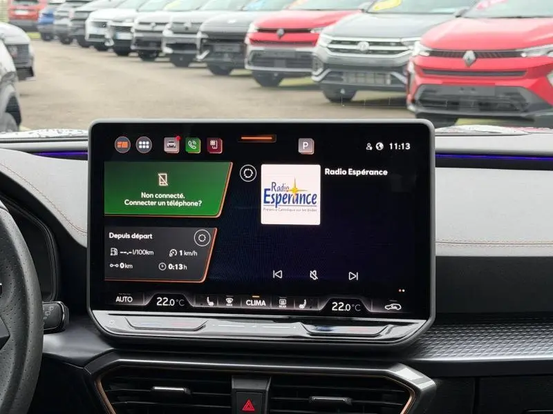 Vue avant intérieure centrée sur l'écran tactile du tableau de bord du CUPRA Formentor gris Graphène 2025, affichant la radio.