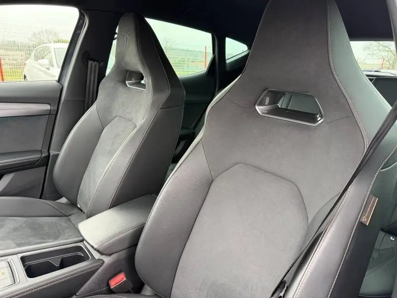 Vue intérieure rapprochée des sièges avant en tissu gris foncé du CUPRA Formentor 1.5 eTSI Hybrid 2025.