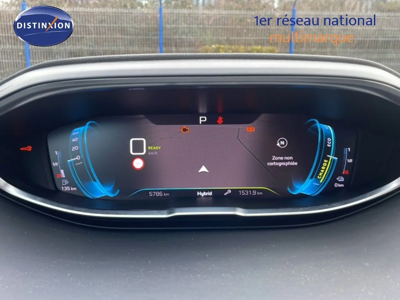 Vue rapprochée du tableau de bord numérique du Peugeot 3008 hybride, affichage en bleu et noir avec informations de conduite.
