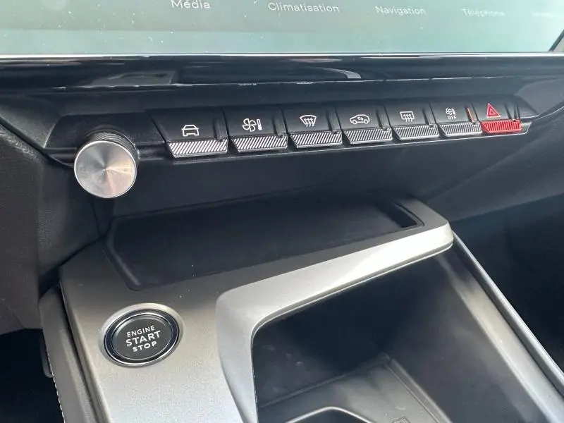 Vue rapprochée de la console centrale intérieure de la Peugeot 308 bleu Obsession avec boutons de commande et bouton start/stop.