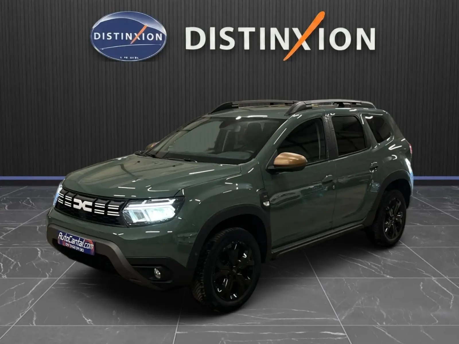 Dacia Duster 2024 kaki lichen en 3/4 avant droit, avec jantes noires et coques de rétroviseurs bronze.