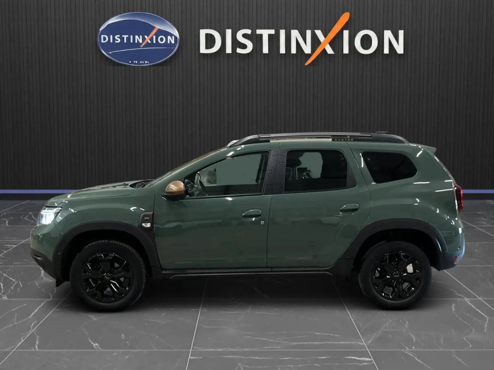 Profil droit du Dacia Duster 2024 kaki lichen avec jantes noires et rétroviseurs couleur bronze.