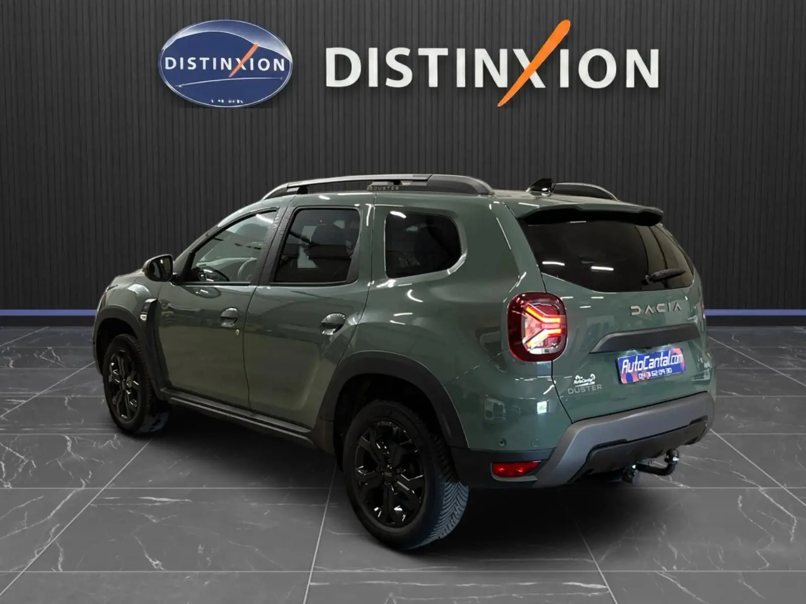 Vue 3/4 arrière droite du Dacia Duster 2024 kaki lichen avec jantes noires et feux arrière LED allumés.
