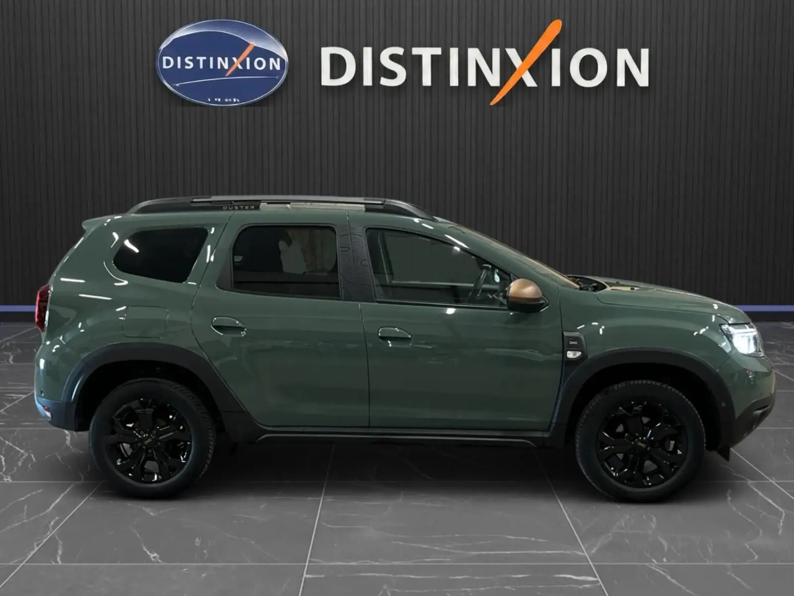 Profil gauche du Dacia Duster 2024 kaki lichen avec jantes noires et rétroviseurs couleur bronze, finition Extreme.