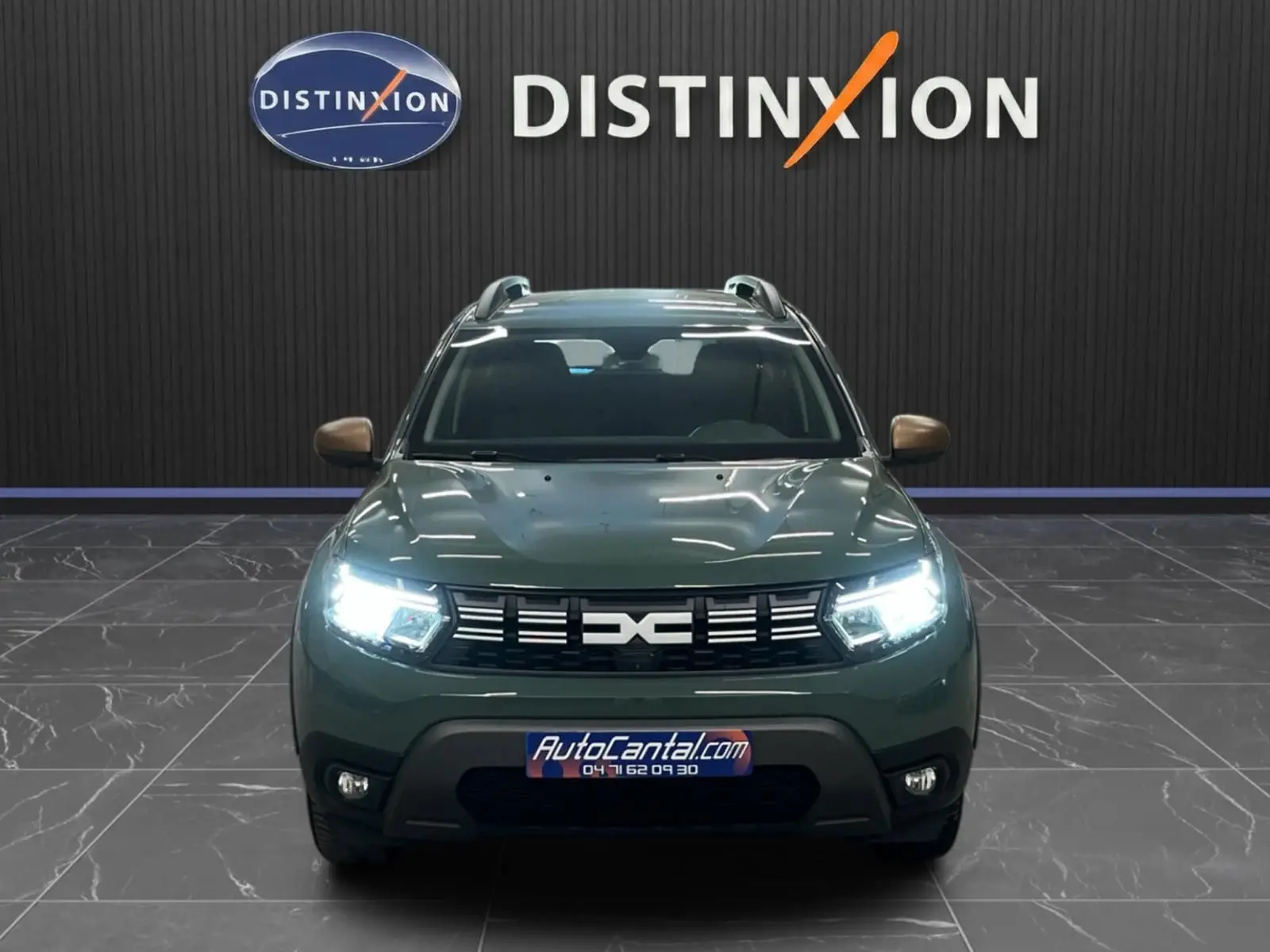 Vue frontale d'un Dacia Duster 2024 kaki lichen avec phares LED allumés et calandre noire distinctive.