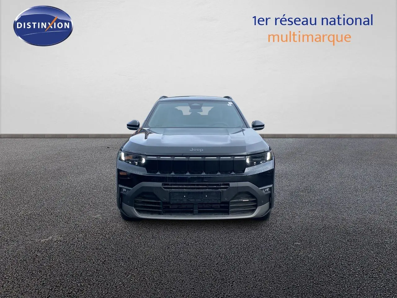 Vue frontale d'un Jeep Compass noir Vulcano métal 2026 avec calandre noire et phares LED allumés.