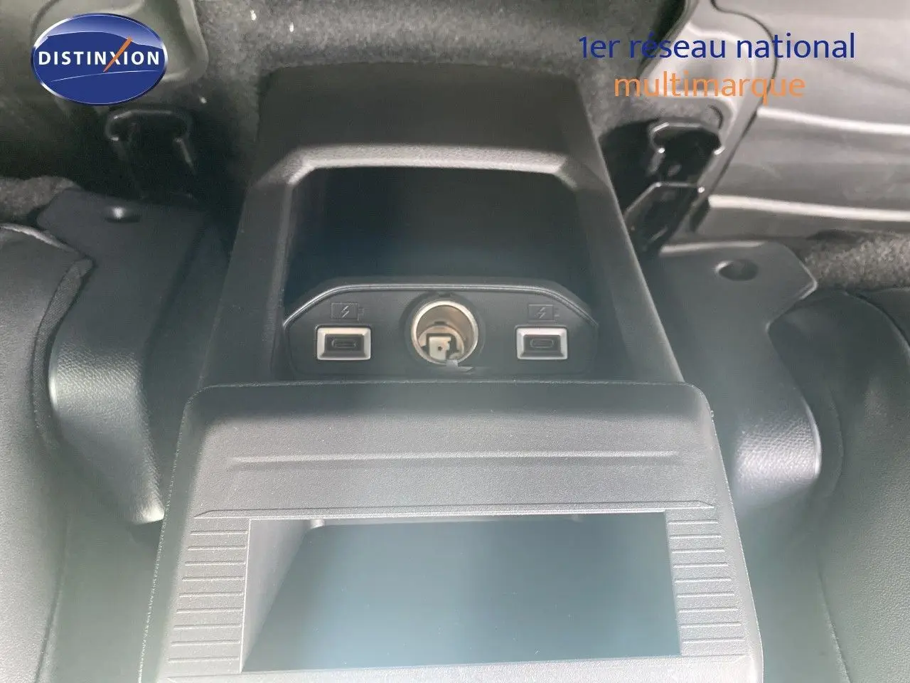 Prise USB et allume-cigare dans le coffre du Jeep Compass noir Vulcano, vue en plongée centrée sur les connectiques.