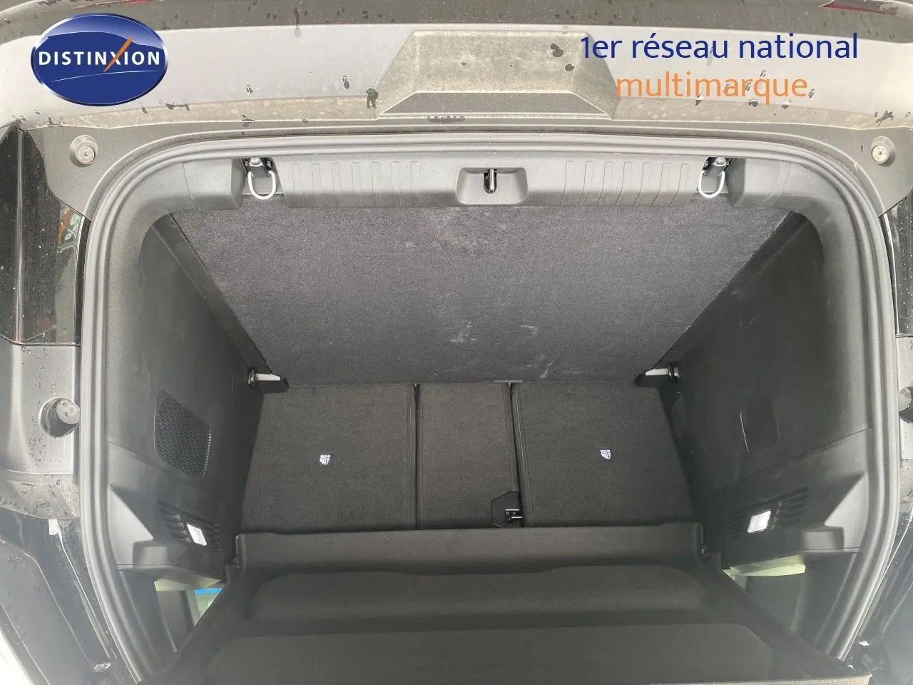 Coffre ouvert d’un Jeep Compass noir Vulcano, vue de l’arrière montrant l’espace de chargement et la tablette cache-bagages.