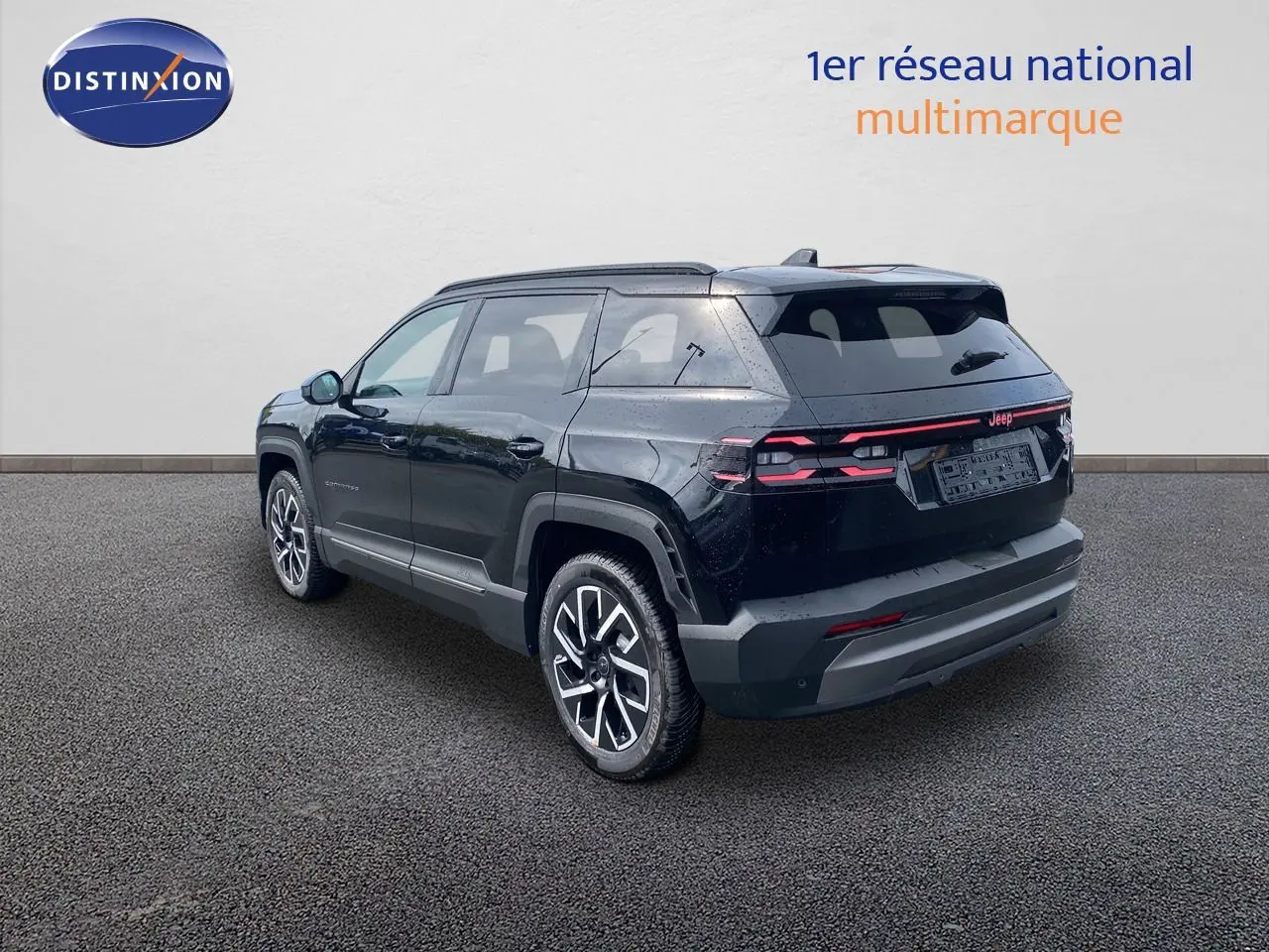 Jeep Compass noir Vulcano métal en vue 3/4 arrière droit, soulignant ses feux arrière LED et ses jantes alliage bicolores.