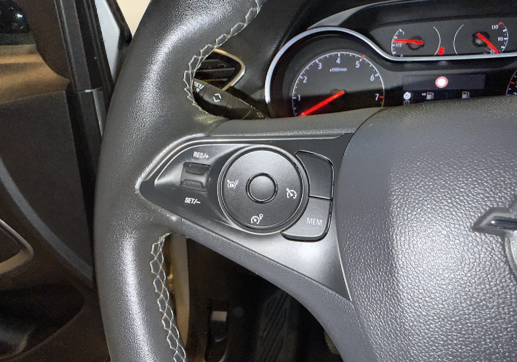 Gros plan sur le volant côté gauche d’un Opel Crossland gris 2023, montrant les commandes de régulateur de vitesse.
