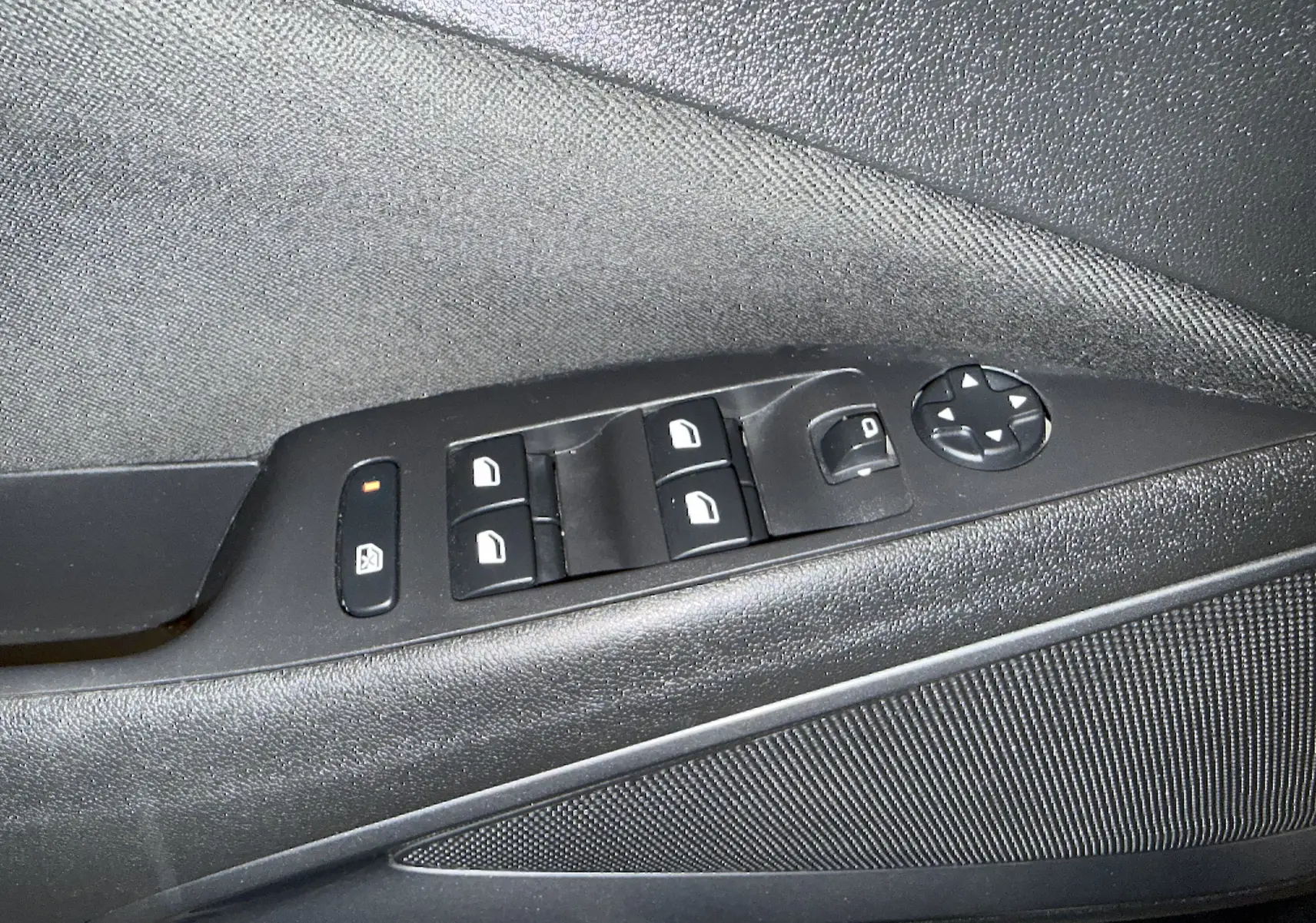 Gros plan sur la commande des vitres et rétroviseurs côté conducteur d’une Opel Crossland gris 2023.