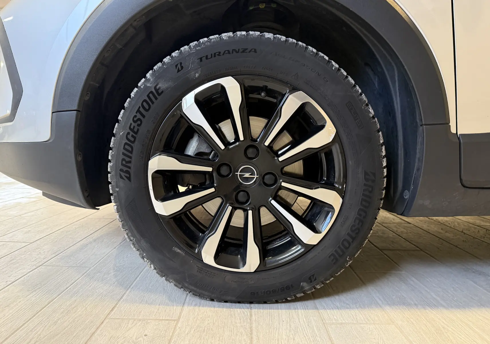 Gros plan sur la roue avant droite gris clair de l’Opel Crossland 2023 avec jante noire et argentée distinctive.