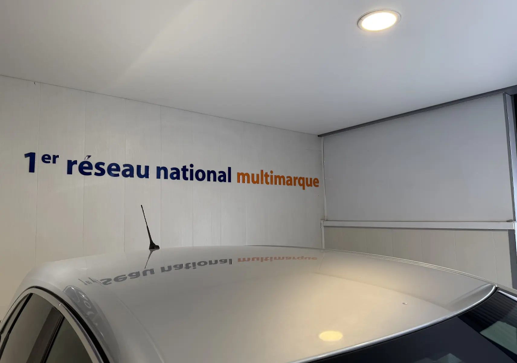 Toit gris d'une Opel Crossland 2023 visible en léger angle intérieur sous un plafond avec éclairage LED.