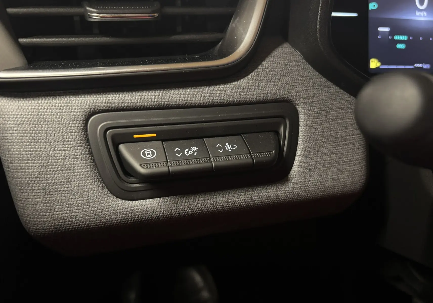 Gros plan sur les commandes de réglage d’éclairage et verrouillage dans l’habitacle gris noir du Renault Clio TCe 90ch Evolution 2024.