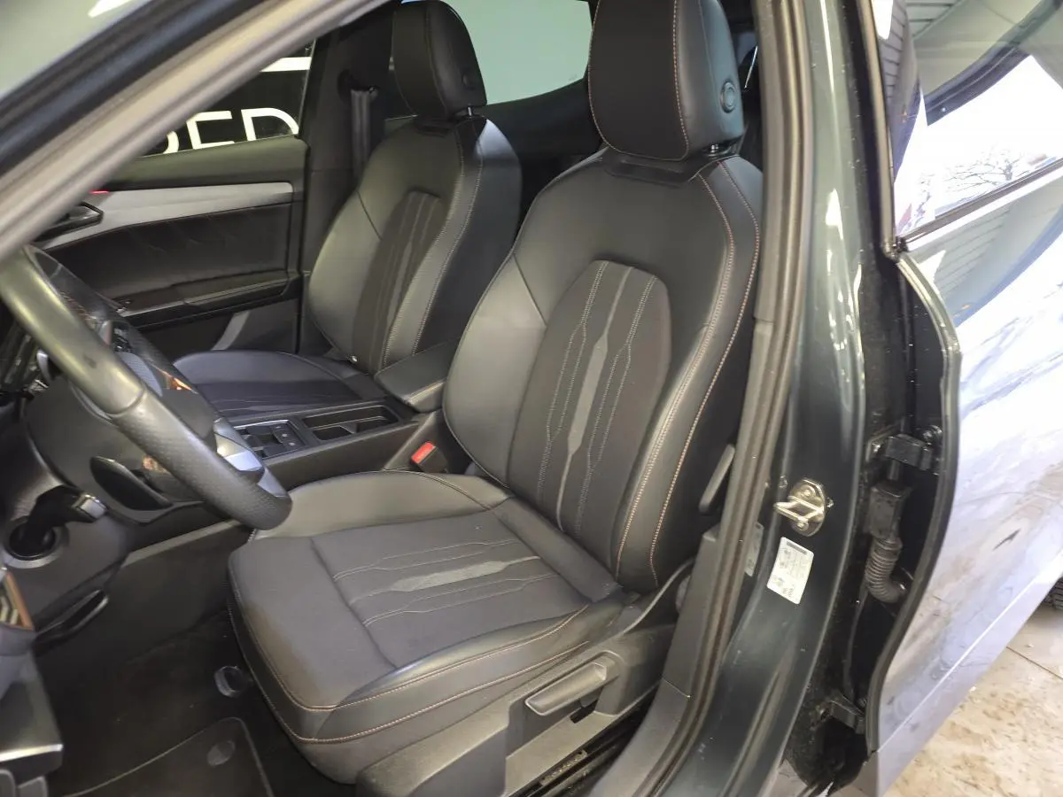 Vue intérieure côté conducteur du CUPRA Formentor gris, mettant en valeur les sièges sport noirs avec surpiqûres cuivre.