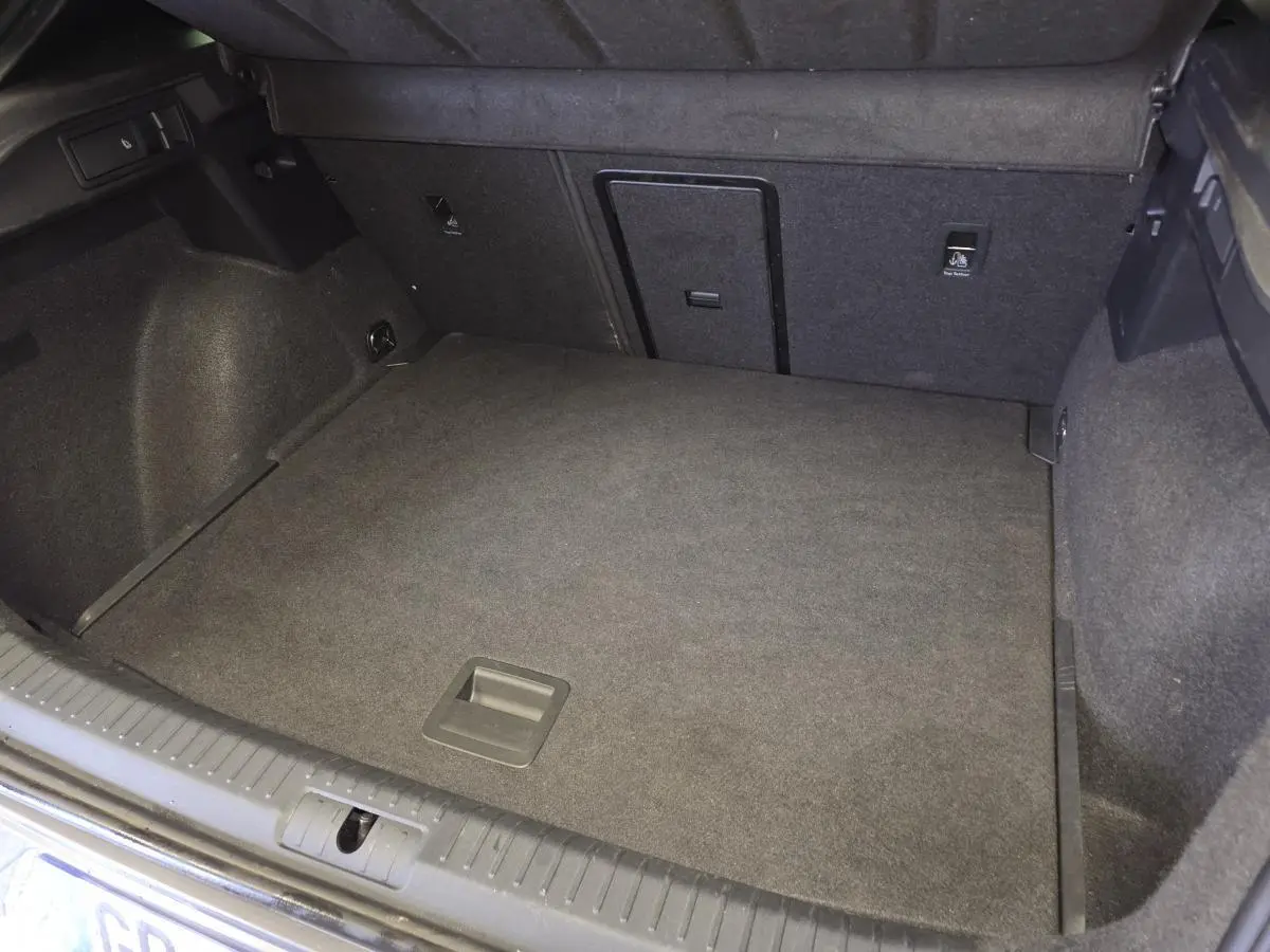 Vue du coffre spacieux et vide du CUPRA Formentor gris, mettant en valeur son revêtement intérieur en tissu sombre.