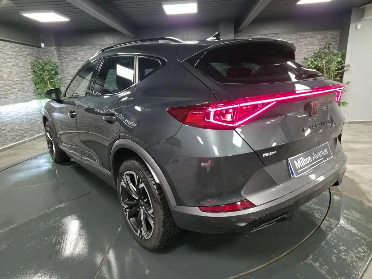 Vue 3/4 arrière droite du CUPRA Formentor gris avec feux arrière LED en bandeau lumineux et jantes alliage noires.
