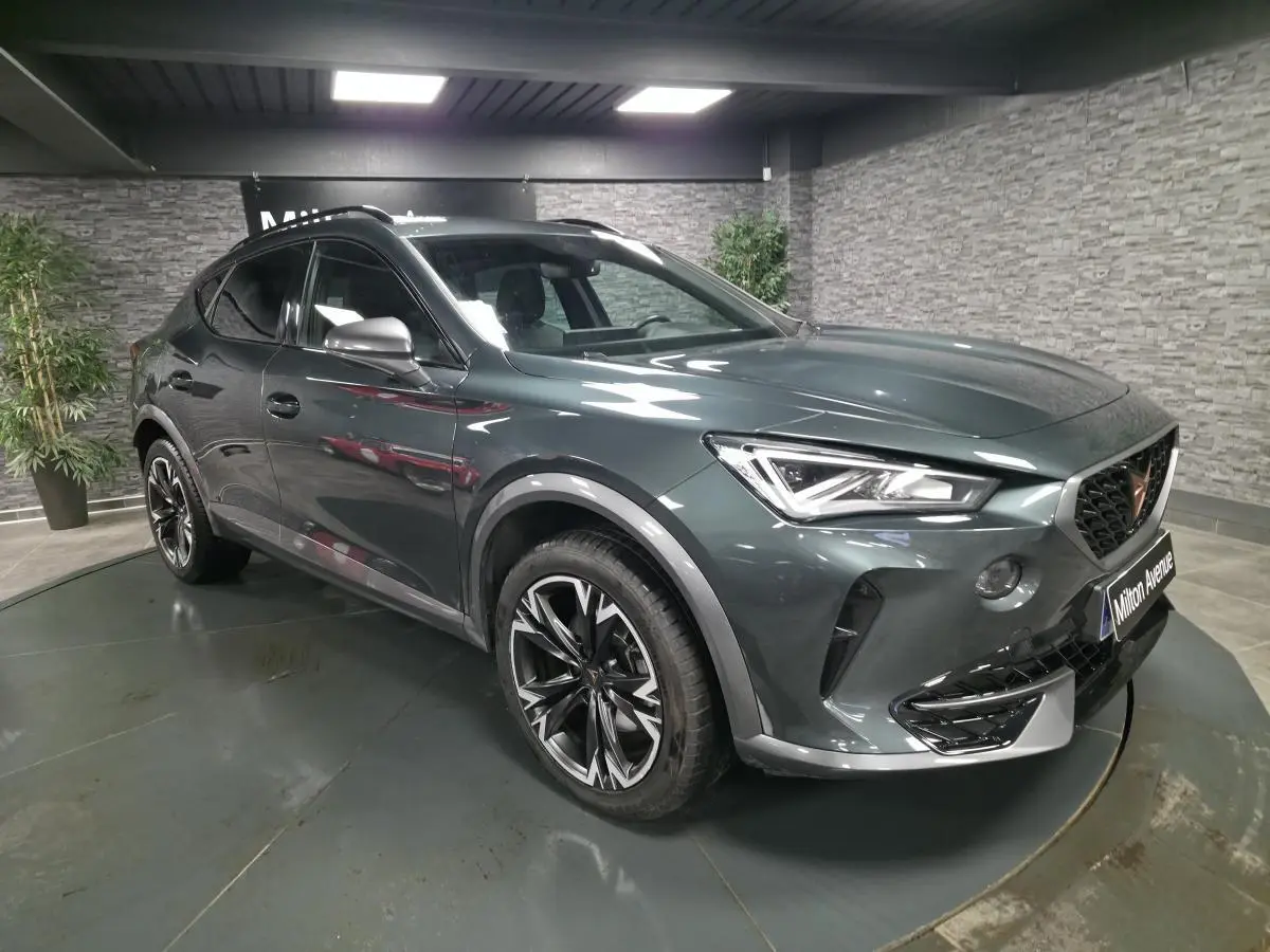 Vue 3/4 avant droite d'un CUPRA Formentor gris Caiman avec jantes alliage 18'' et toit panoramique noir.