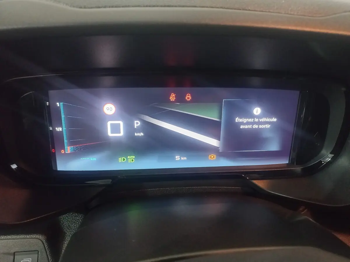 Vue rapprochée du tableau de bord numérique du Citroën Berlingo blanc 2025, affichant la vitesse et alertes.