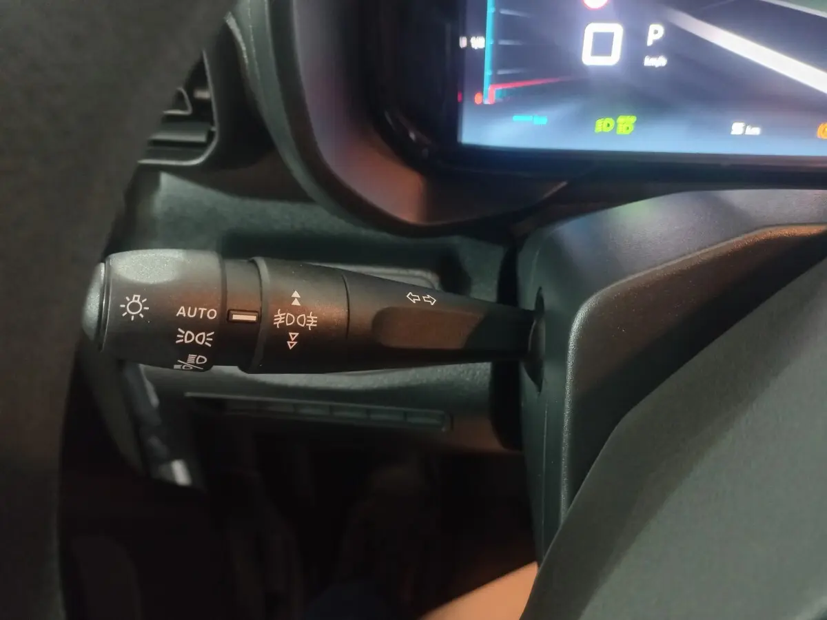 Gros plan sur la manette de commande des feux à gauche du volant dans l’habitacle du Citroën Berlingo blanc 2025.