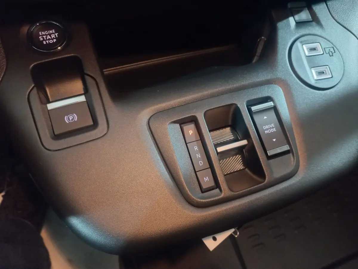 Gros plan sur la console centrale noire du Citroën Berlingo XL 2025 avec boutons de boîte auto et mode de conduite.