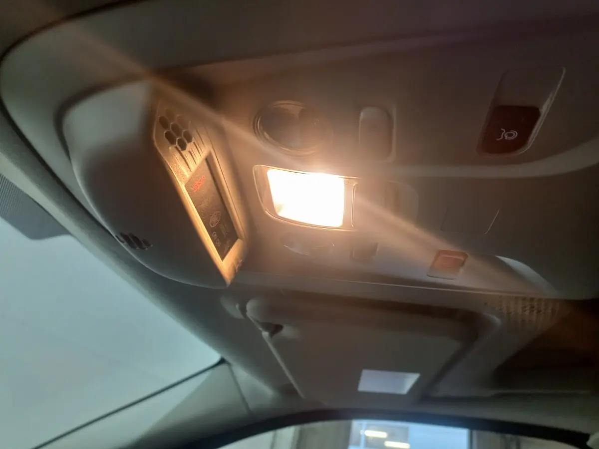 Plafonnier intérieur allumé avec commandes et détecteur dans un Citroën Berlingo XL blanc, vue de l'habitacle avant.