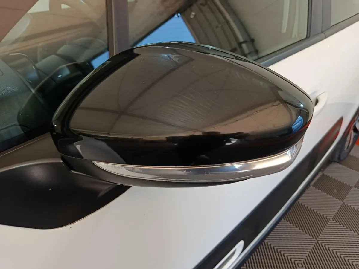 Rétroviseur extérieur noir côté gauche d'une Citroën C3 blanche vue en gros plan sur porte avant.
