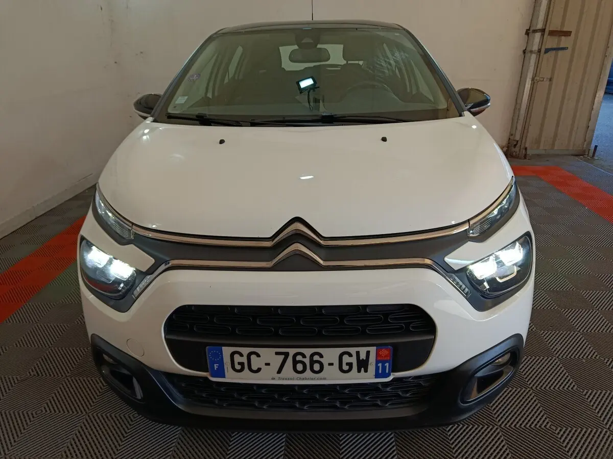 Vue avant d'une Citroën C3 blanche 2021 avec phares LED allumés et calandre noire distinctive.